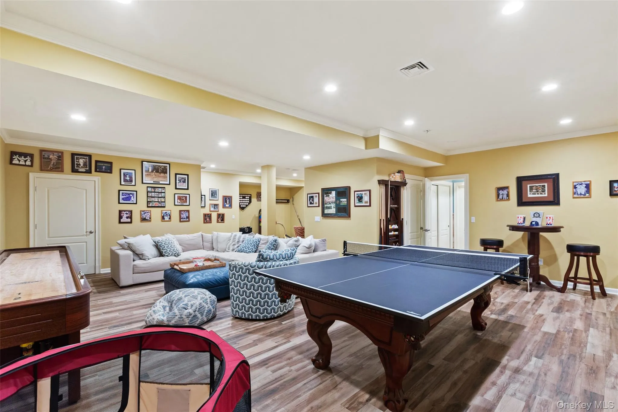 Game room with recessed lighting, wood finished floors, ornamental molding, and baseboards Game room with recessed lighting, wood finished floors, ornamental molding, and baseboards