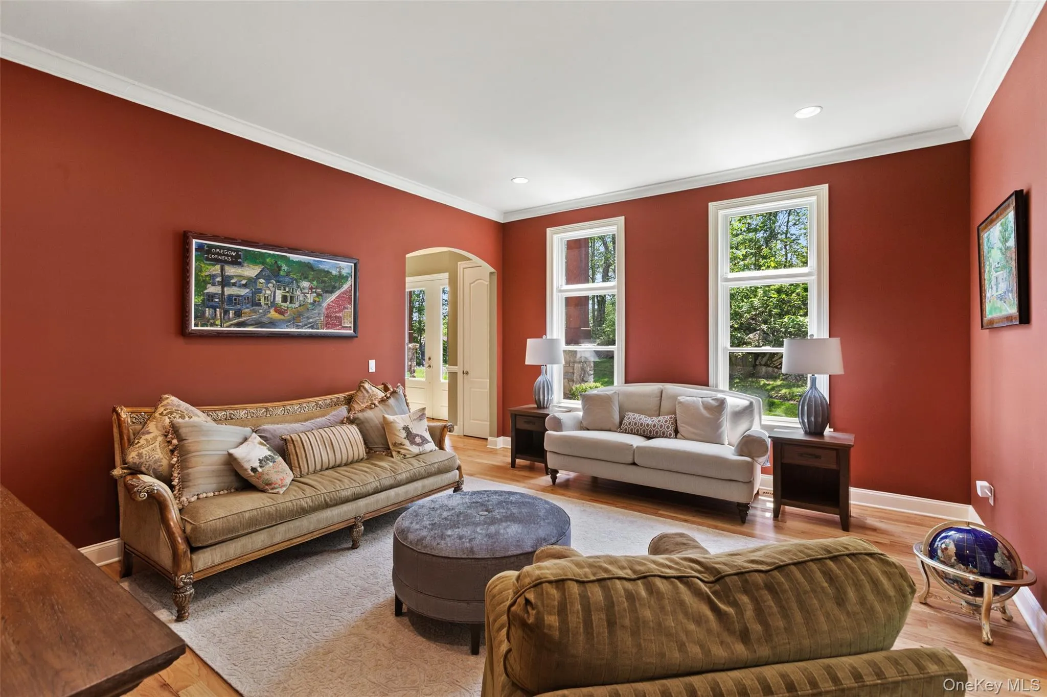 Living area featuring arched walkways, crown molding, light wood finished floors, baseboards, and recessed lighting Living area featuring arched walkways, crown molding, light wood finished floors, baseboards, and recessed lighting