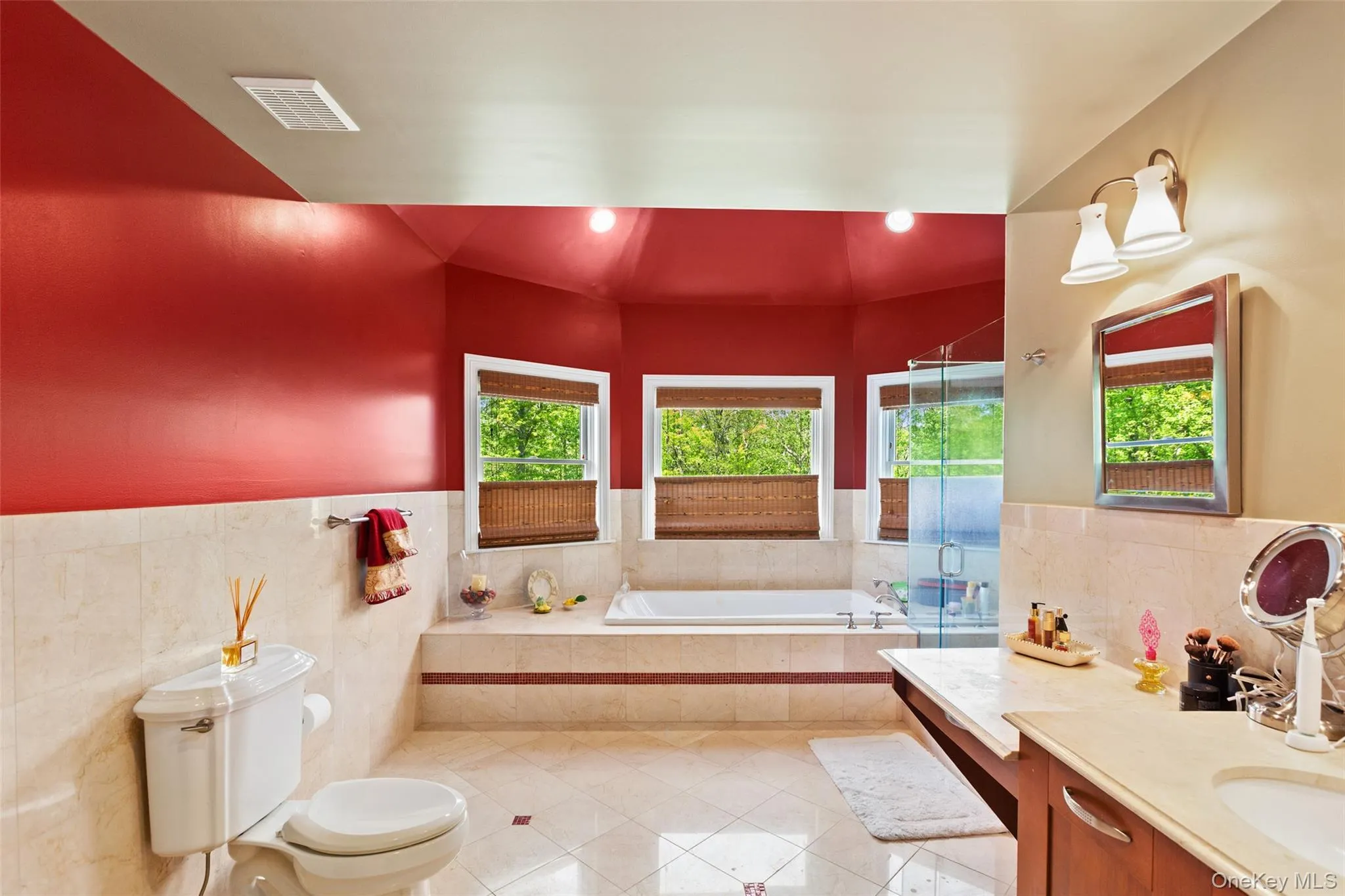 Full bathroom featuring tile patterned flooring, vanity, a garden tub, plenty of natural light, and tile walls Full bathroom featuring tile patterned flooring, vanity, a garden tub, plenty of natural light, and tile walls