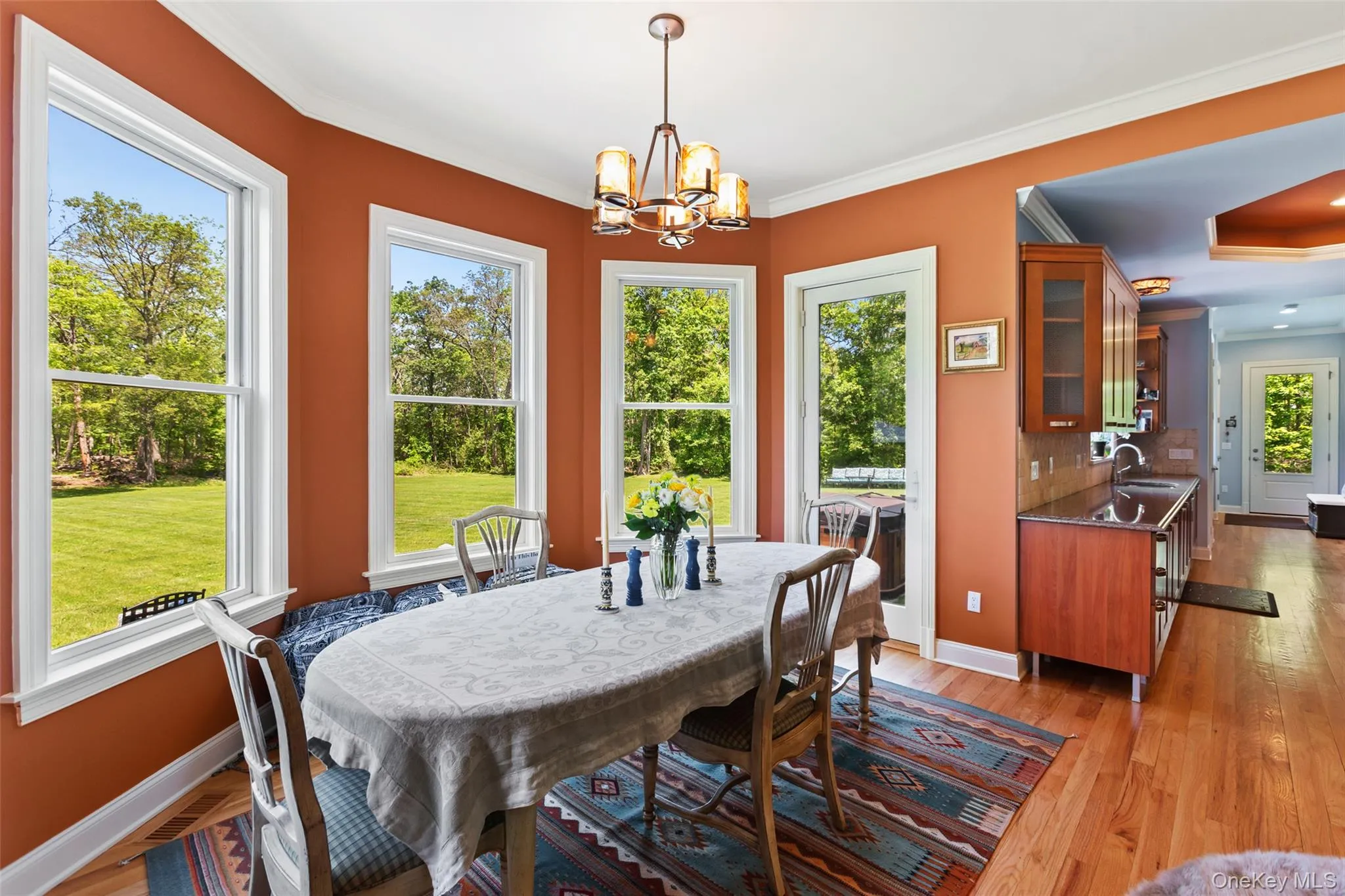 Dining area with a chandelier, baseboards, crown molding, and light wood-type flooring Dining area with a chandelier, baseboards, crown molding, and light wood-type flooring