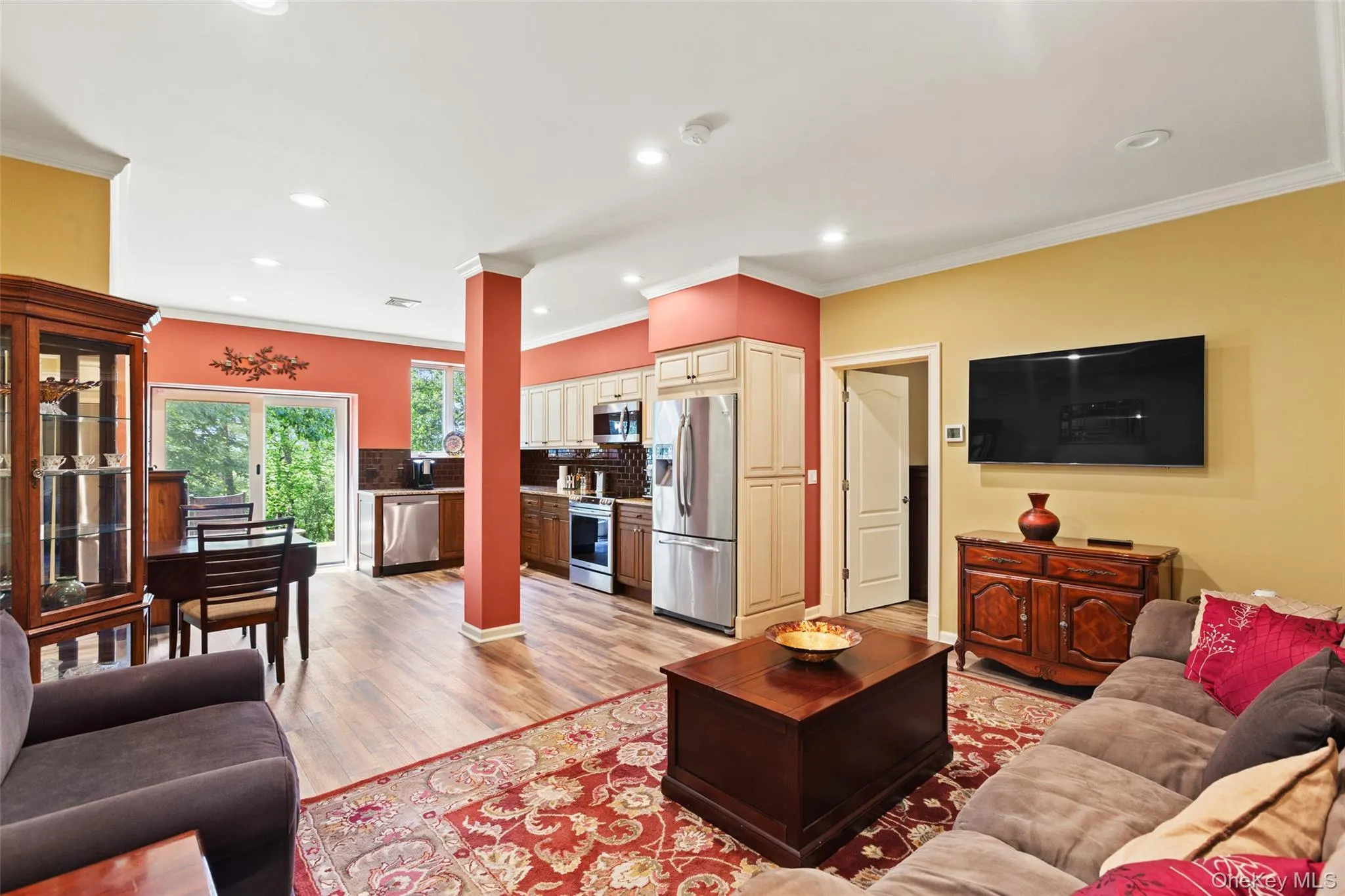 Living area featuring light wood-style flooring, recessed lighting, and ornamental molding Living area featuring light wood-style flooring, recessed lighting, and ornamental molding