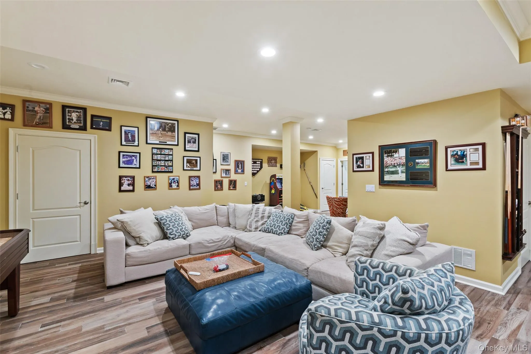 Living area featuring recessed lighting, wood finished floors, crown molding, and baseboards Living area featuring recessed lighting, wood finished floors, crown molding, and baseboards
