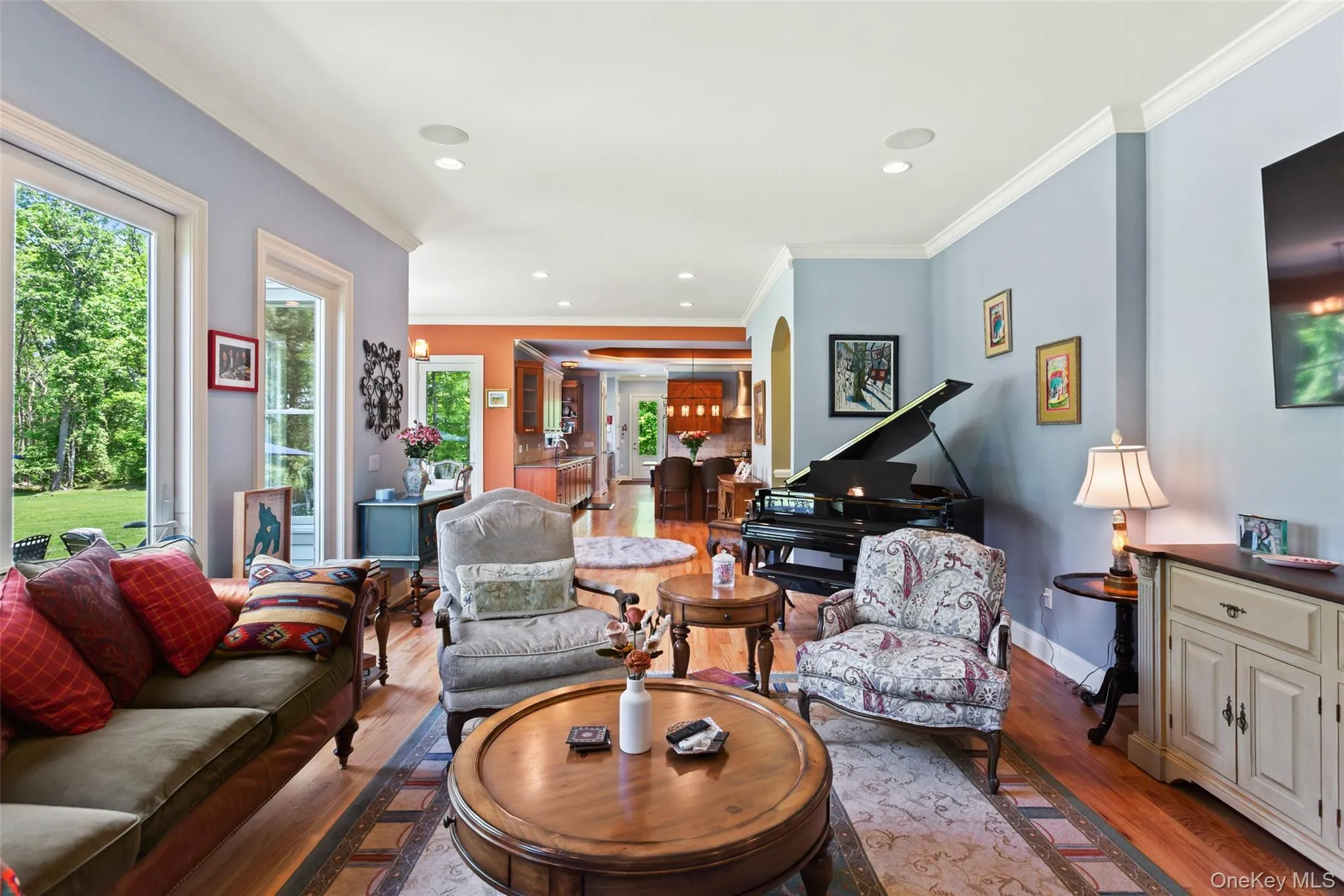 Living area featuring plenty of natural light, wood finished floors, baseboards, recessed lighting, and crown molding Living area featuring plenty of natural light, wood finished floors, baseboards, recessed lighting, and crown molding