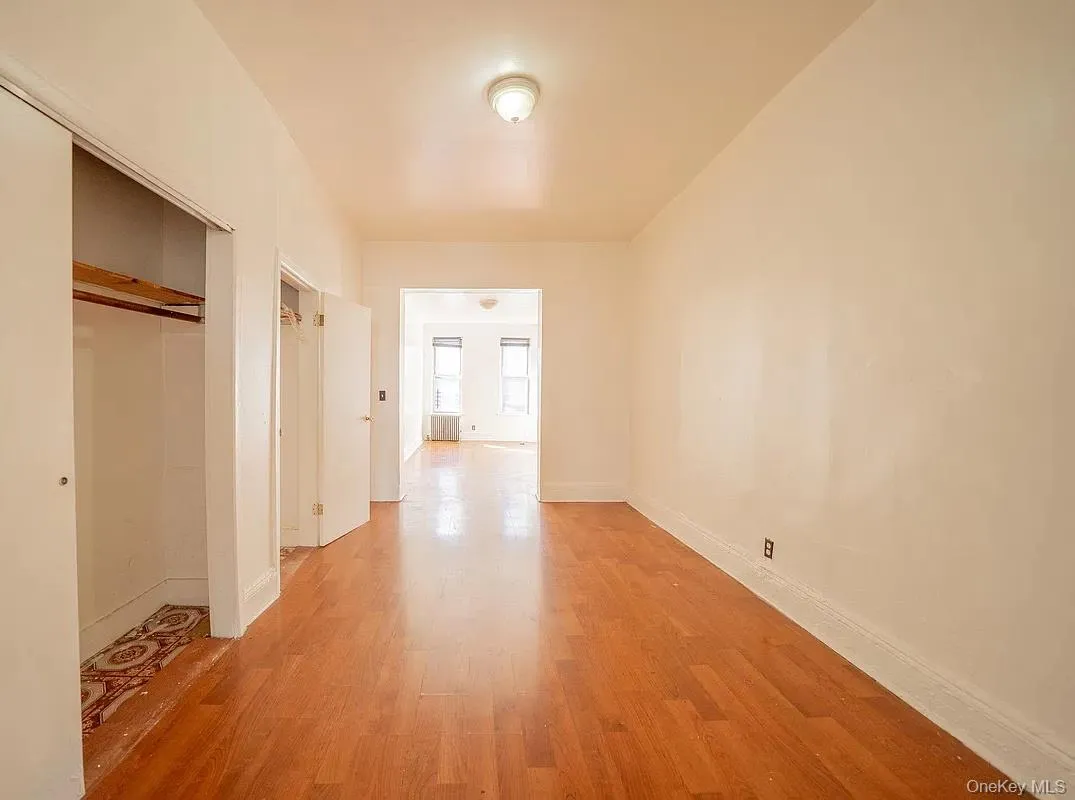 Tile flooring, recessed closet with wooden shelving, and neutral wall finishes Tile flooring, recessed closet with wooden shelving, and neutral wall finishes