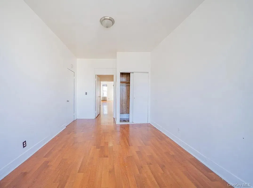 Neutral wall paint, wood-finish flooring, and a built-in closet. Neutral wall paint, wood-finish flooring, and a built-in closet.