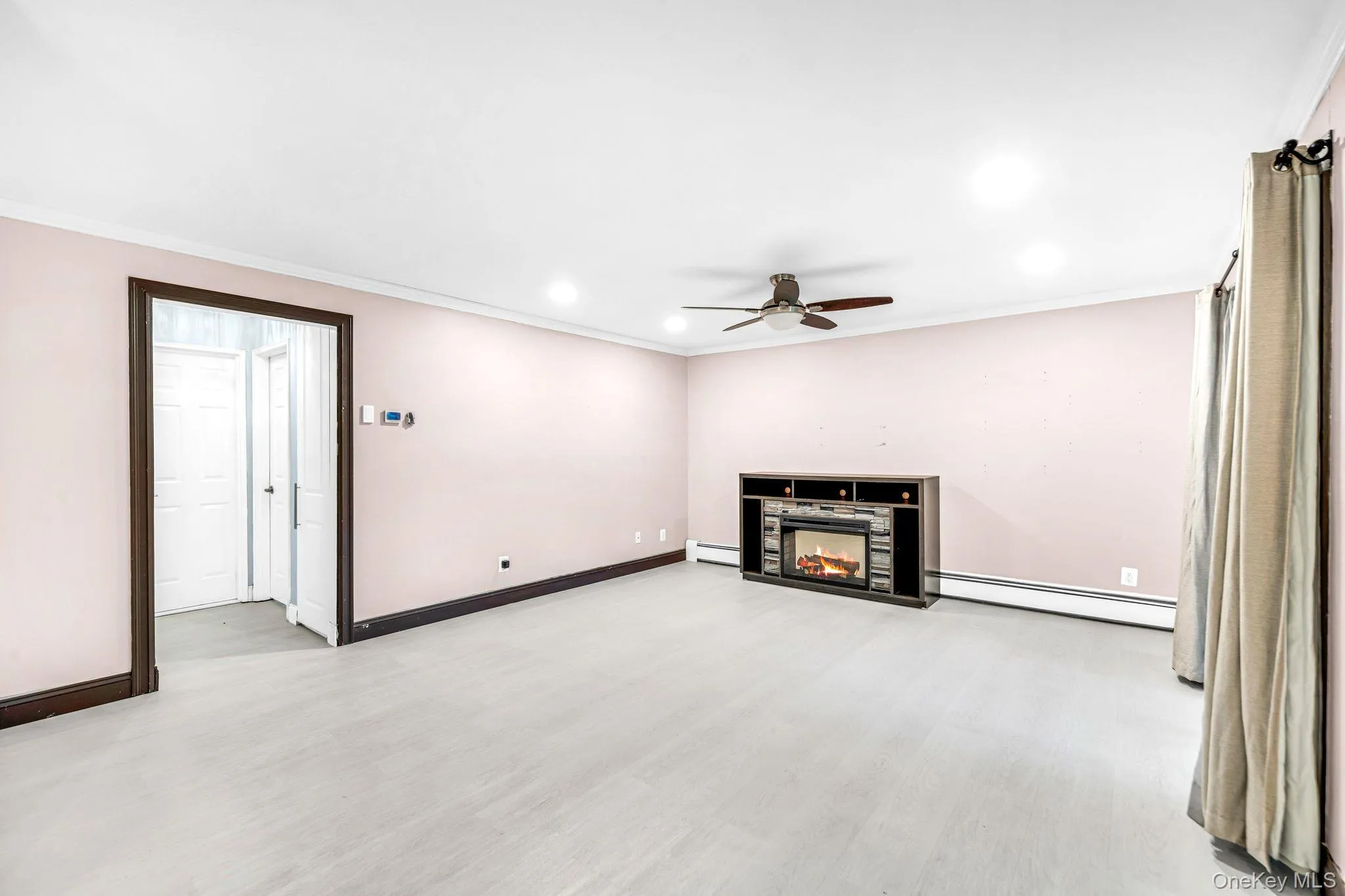 Living area featuring wood-finish flooring, recessed lighting, a ceiling fan, and a built-in fireplace mantle Living area featuring wood-finish flooring, recessed lighting, a ceiling fan, and a built-in fireplace mantle