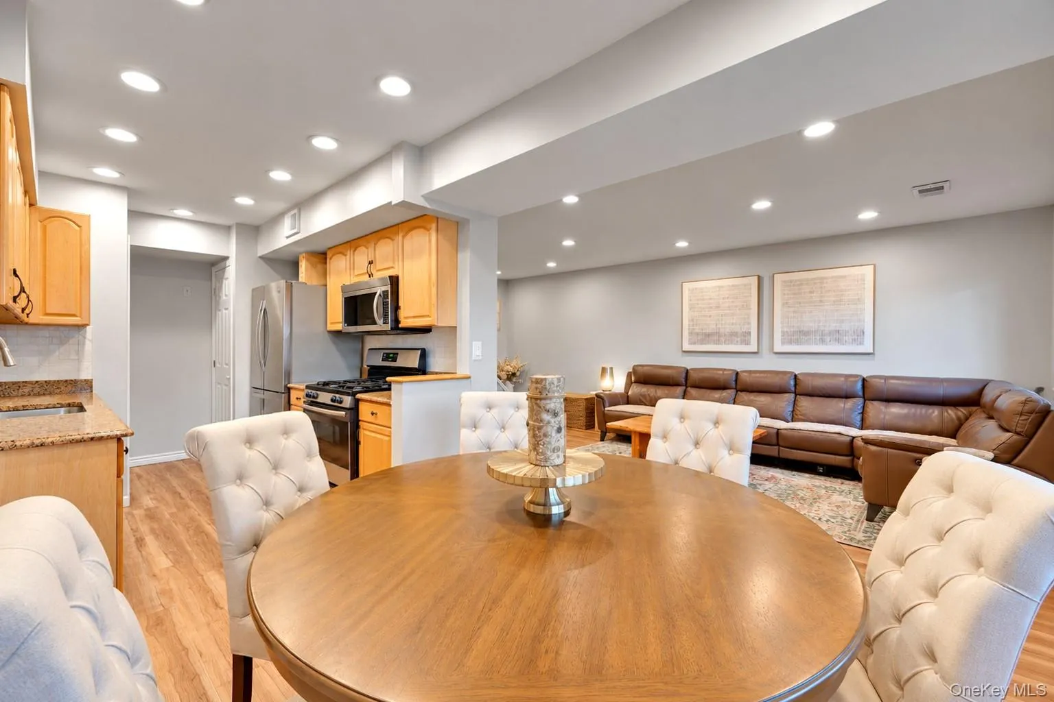 Kitchen featuring wood cabinetry, stone-finish countertops, stainless steel appliances, wood-finish flooring, and recessed lighting throughout Kitchen featuring wood cabinetry, stone-finish countertops, stainless steel appliances, wood-finish flooring, and recessed lighting throughout