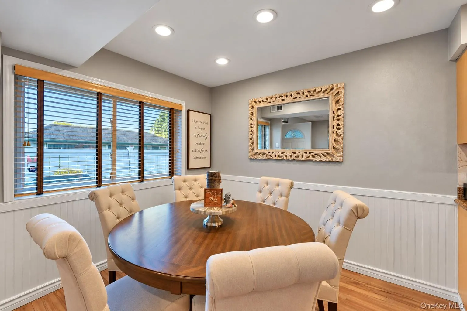 Recessed ceiling lighting, beadboard wainscoting, wood-finish flooring, and large window with horizontal blinds Recessed ceiling lighting, beadboard wainscoting, wood-finish flooring, and large window with horizontal blinds