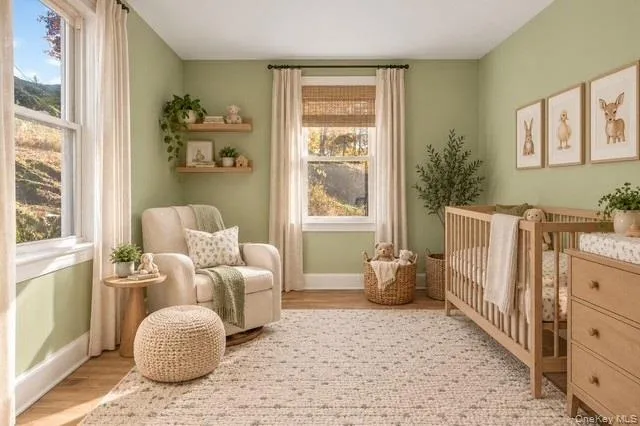 Bright room featuring wood-finish flooring, two large windows, and natural wood floating shelving Bright room featuring wood-finish flooring, two large windows, and natural wood floating shelving