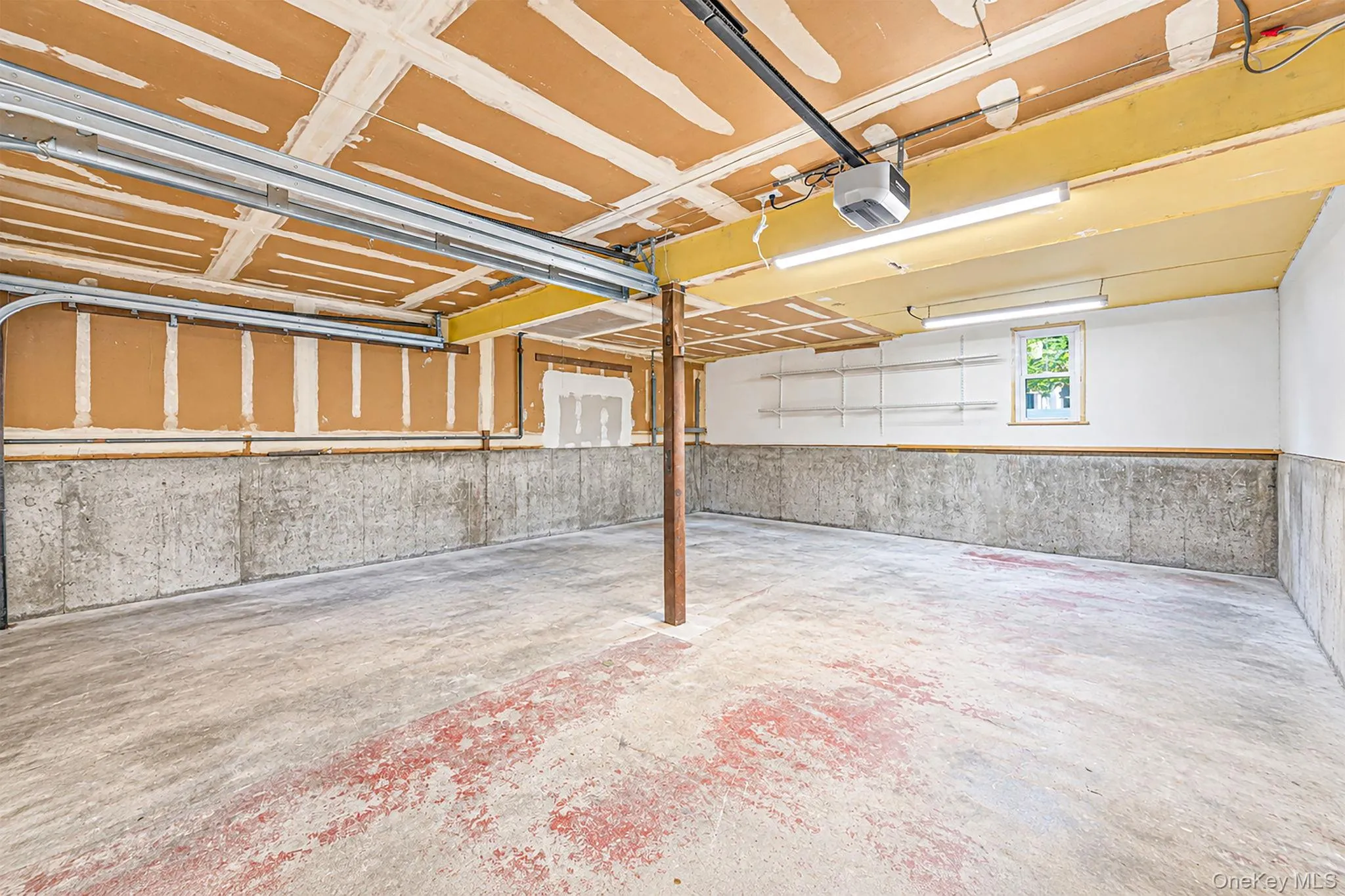 AI-edited photo: Personal belongings digitally removed to show the garage space. No structural features have been altered. AI-edited photo: Personal belongings digitally removed to show the garage space. No structural features have been altered.