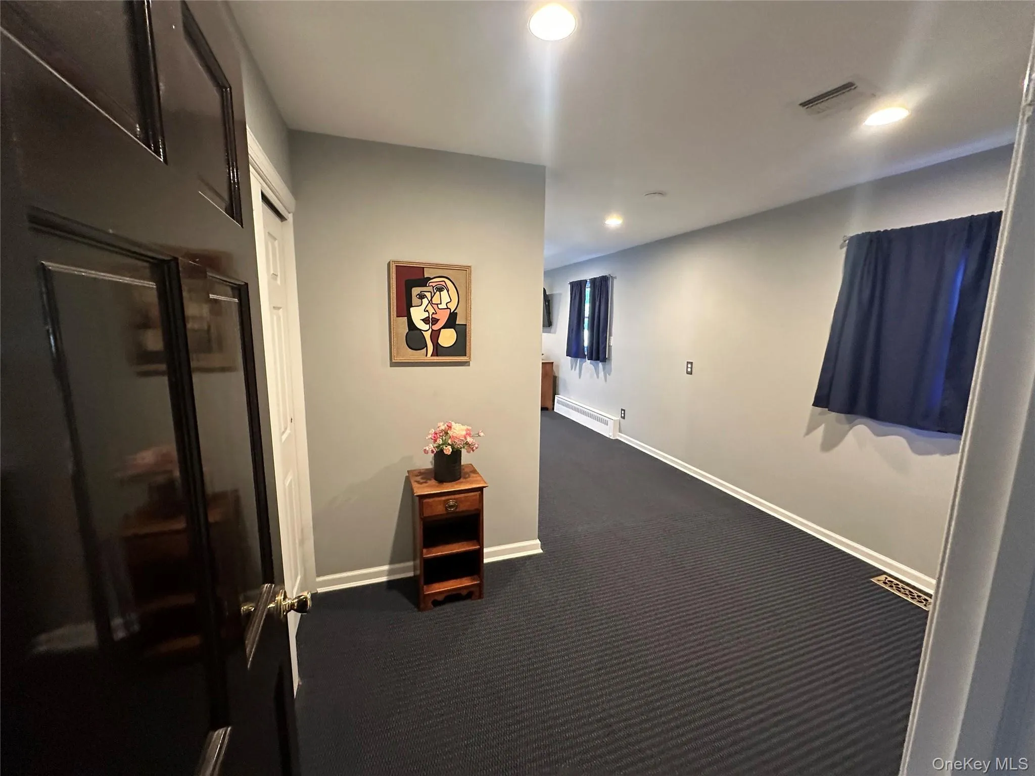 Interior space featuring recessed lighting, wall-to-wall carpeting, and a multi-panel door Interior space featuring recessed lighting, wall-to-wall carpeting, and a multi-panel door
