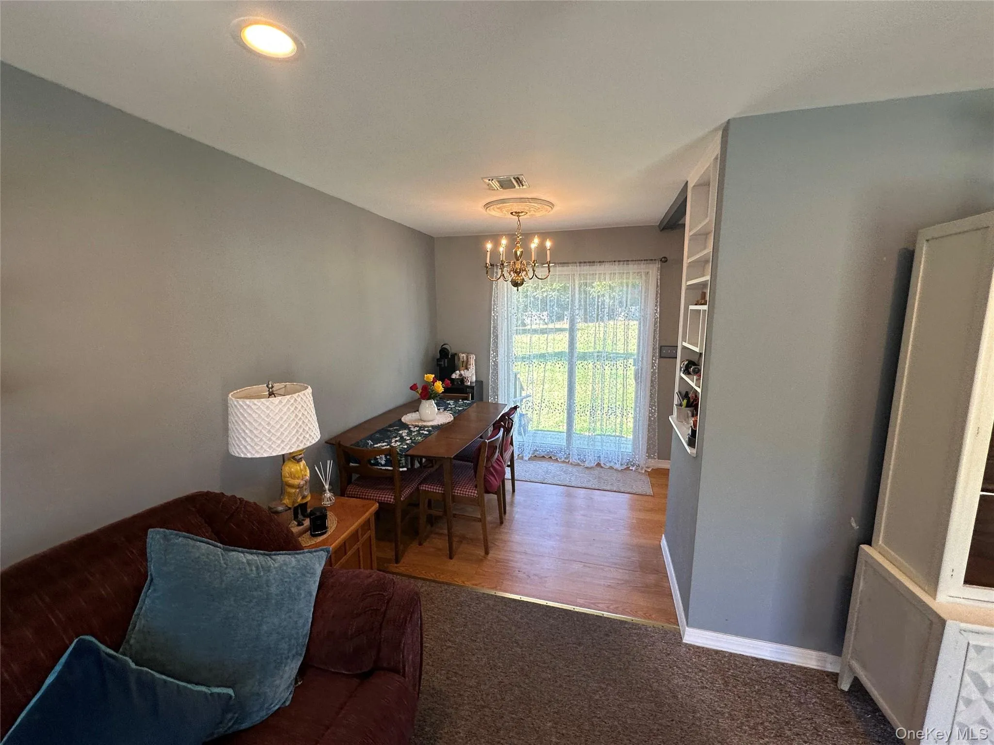 Hardwood flooring, sliding glass door, recessed lighting, ceiling-mounted chandelier with medallion, and built-in wall shelving Hardwood flooring, sliding glass door, recessed lighting, ceiling-mounted chandelier with medallion, and built-in wall shelving