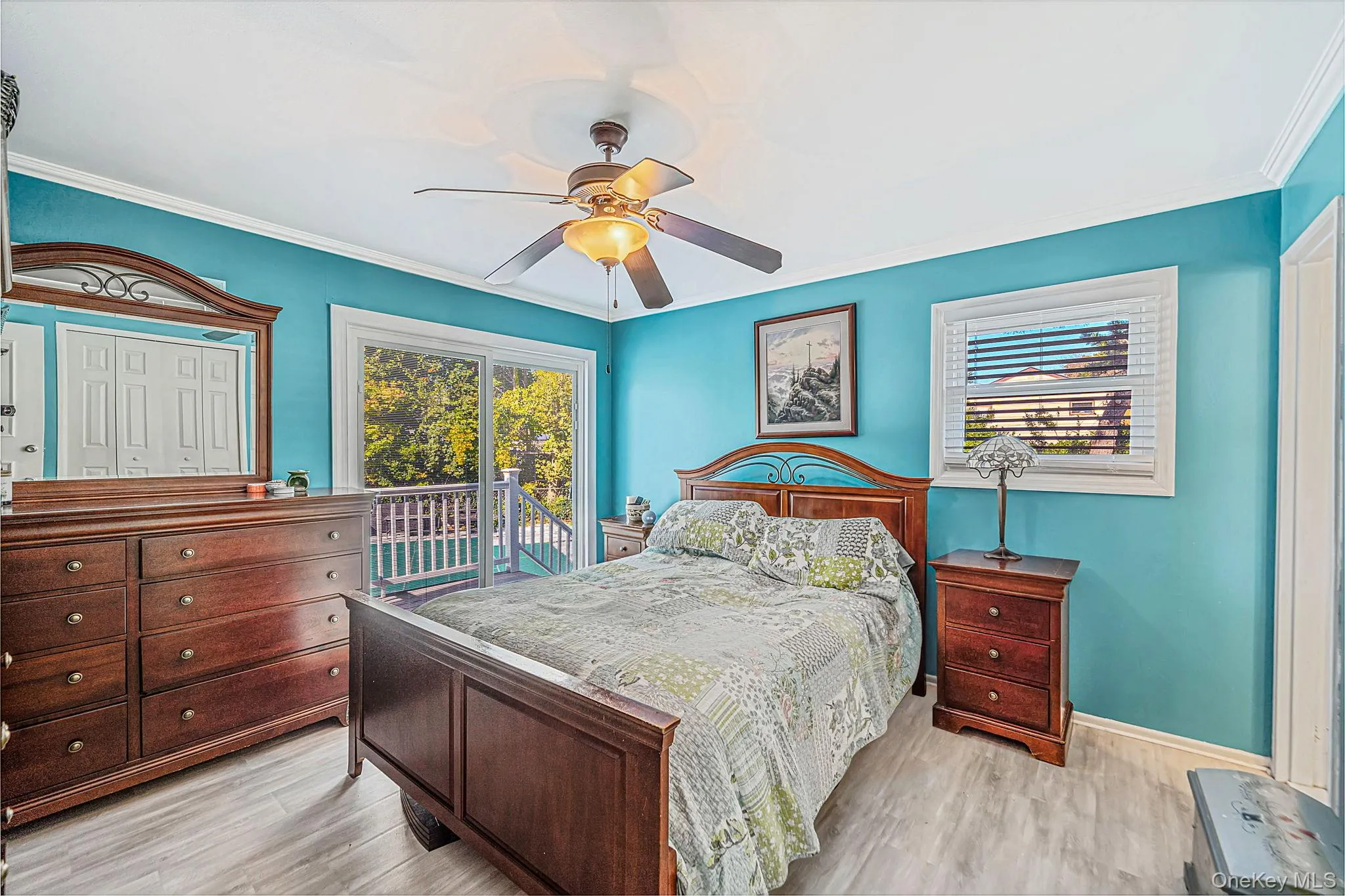 Wood-finish flooring, ceiling fan with integrated light fixture, sliding glass doors, and window blinds Wood-finish flooring, ceiling fan with integrated light fixture, sliding glass doors, and window blinds