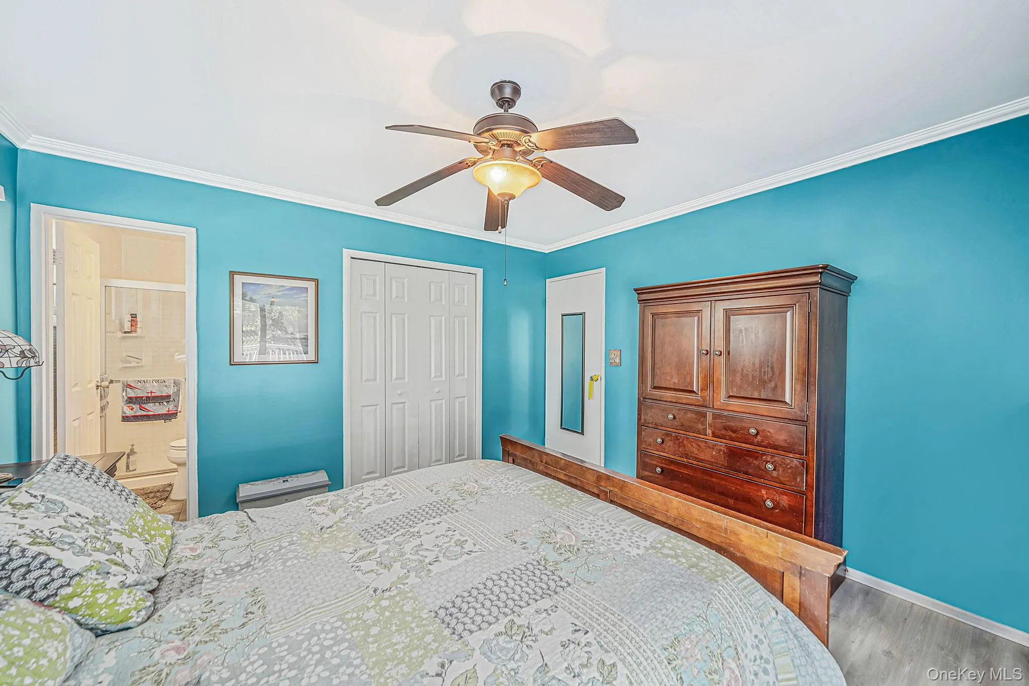Room featuring a ceiling fan with integrated lighting, wood-finish flooring, and a multi-panel closet door Room featuring a ceiling fan with integrated lighting, wood-finish flooring, and a multi-panel closet door