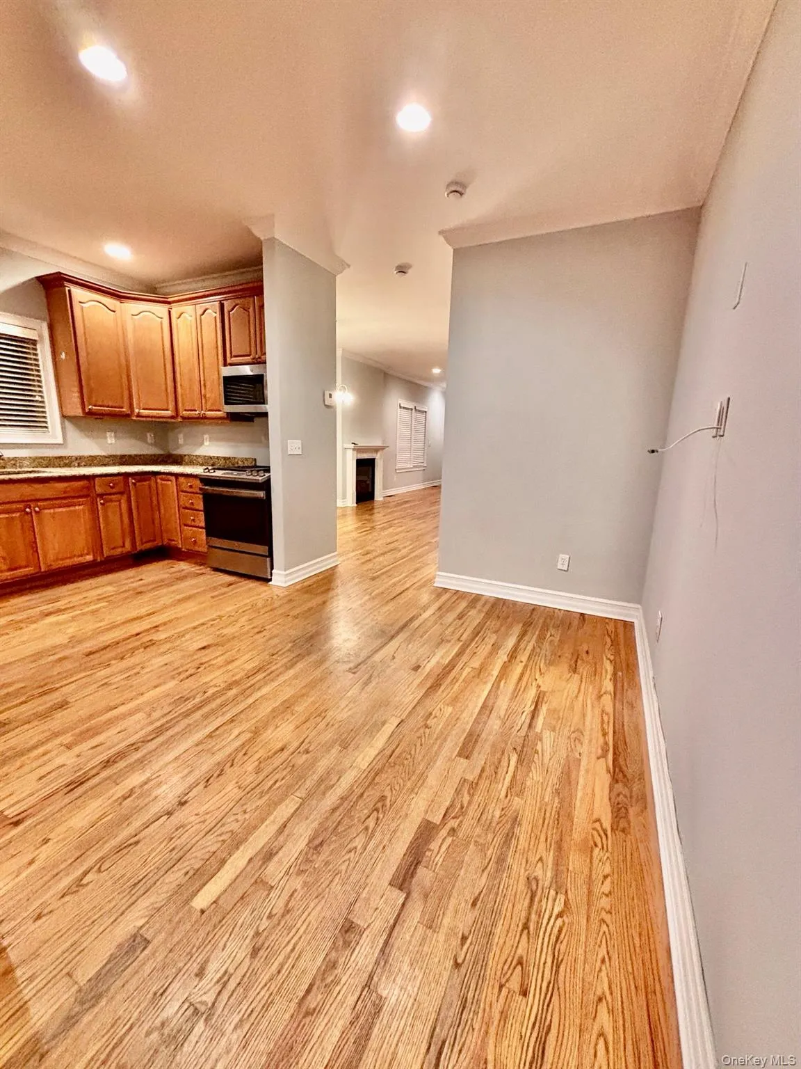 Kitchen with recessed lighting, appliances with stainless steel finishes, light wood finished floors, brown cabinets, and open floor plan Kitchen with recessed lighting, appliances with stainless steel finishes, light wood finished floors, brown cabinets, and open floor plan