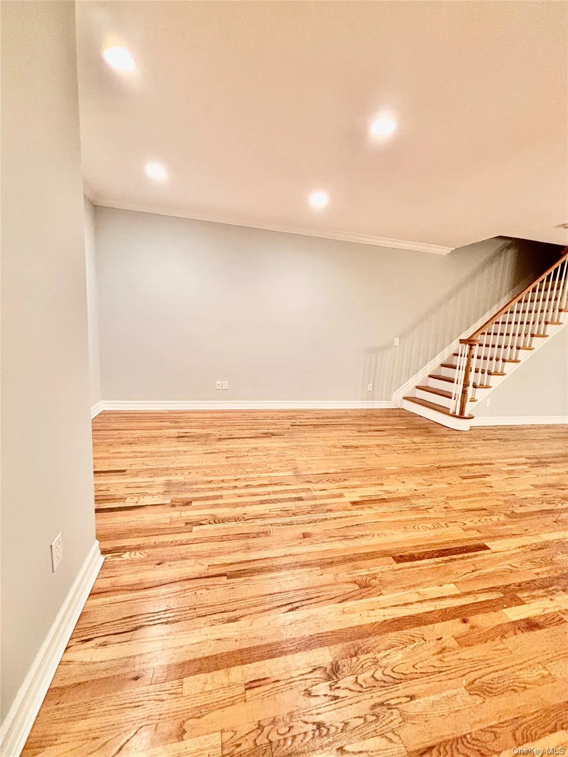 Basement with stairs, recessed lighting, light wood-type flooring, and ornamental molding Basement with stairs, recessed lighting, light wood-type flooring, and ornamental molding