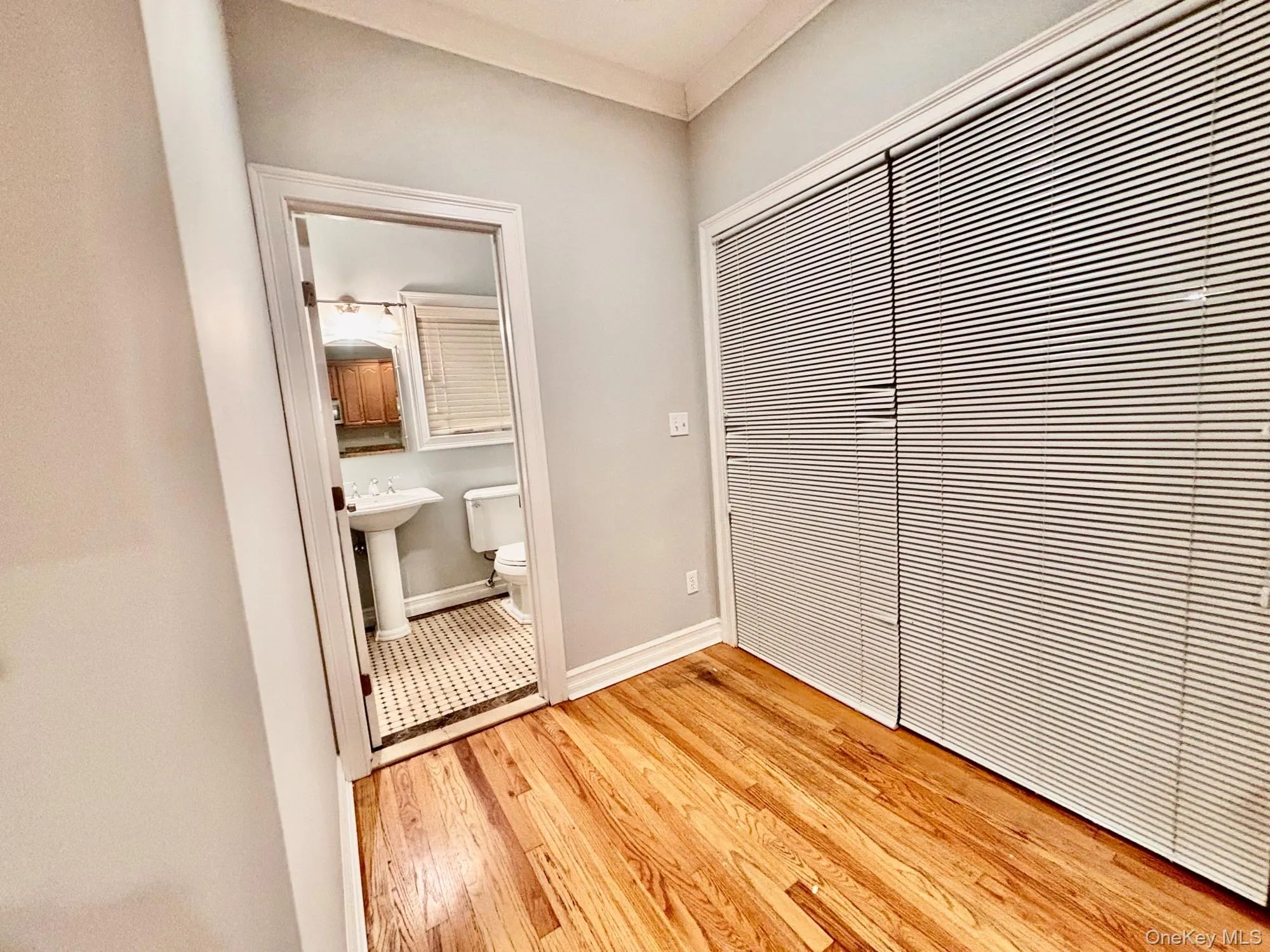 Unfurnished bedroom featuring light wood-style floors, a closet, and ensuite bath Unfurnished bedroom featuring light wood-style floors, a closet, and ensuite bath