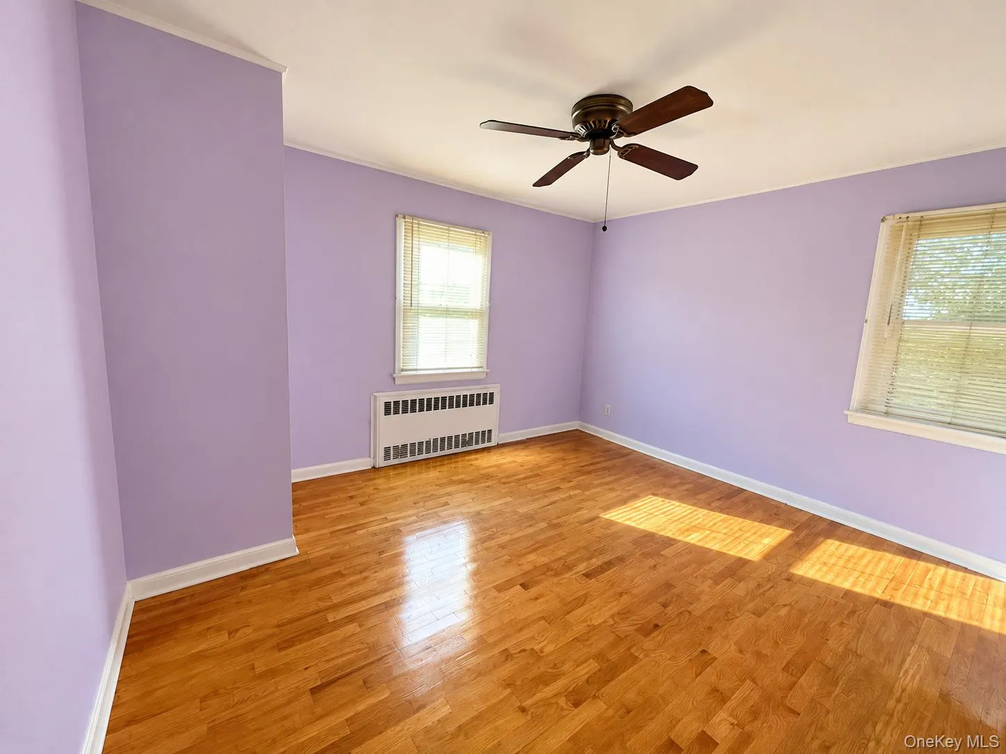 Hardwood flooring, ceiling fan with light fixture, and dual windows with blinds Hardwood flooring, ceiling fan with light fixture, and dual windows with blinds