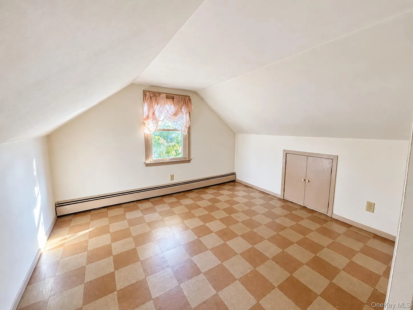 Sloped ceilings with recessed knee-wall storage cabinetry and a single-pane window with wood tirm Sloped ceilings with recessed knee-wall storage cabinetry and a single-pane window with wood tirm