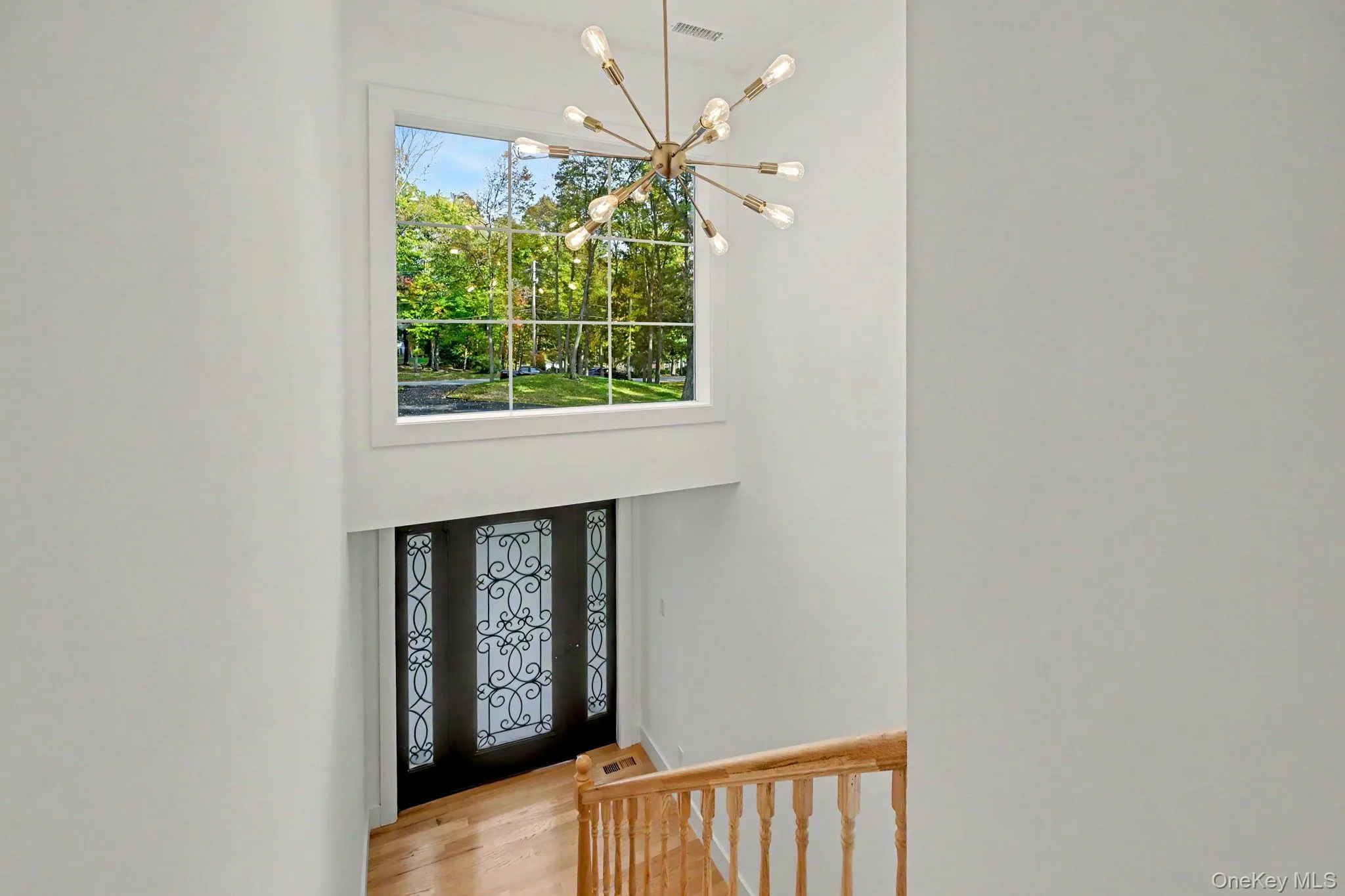 A magnificent entryway window frames the tranquil landscape, inviting the vibrant beauty of nature indoors and filling the home with an abundance of natural light. A magnificent entryway window frames the tranquil landscape, inviting the vibrant beauty of nature indoors and filling the home with an abundance of natural light.