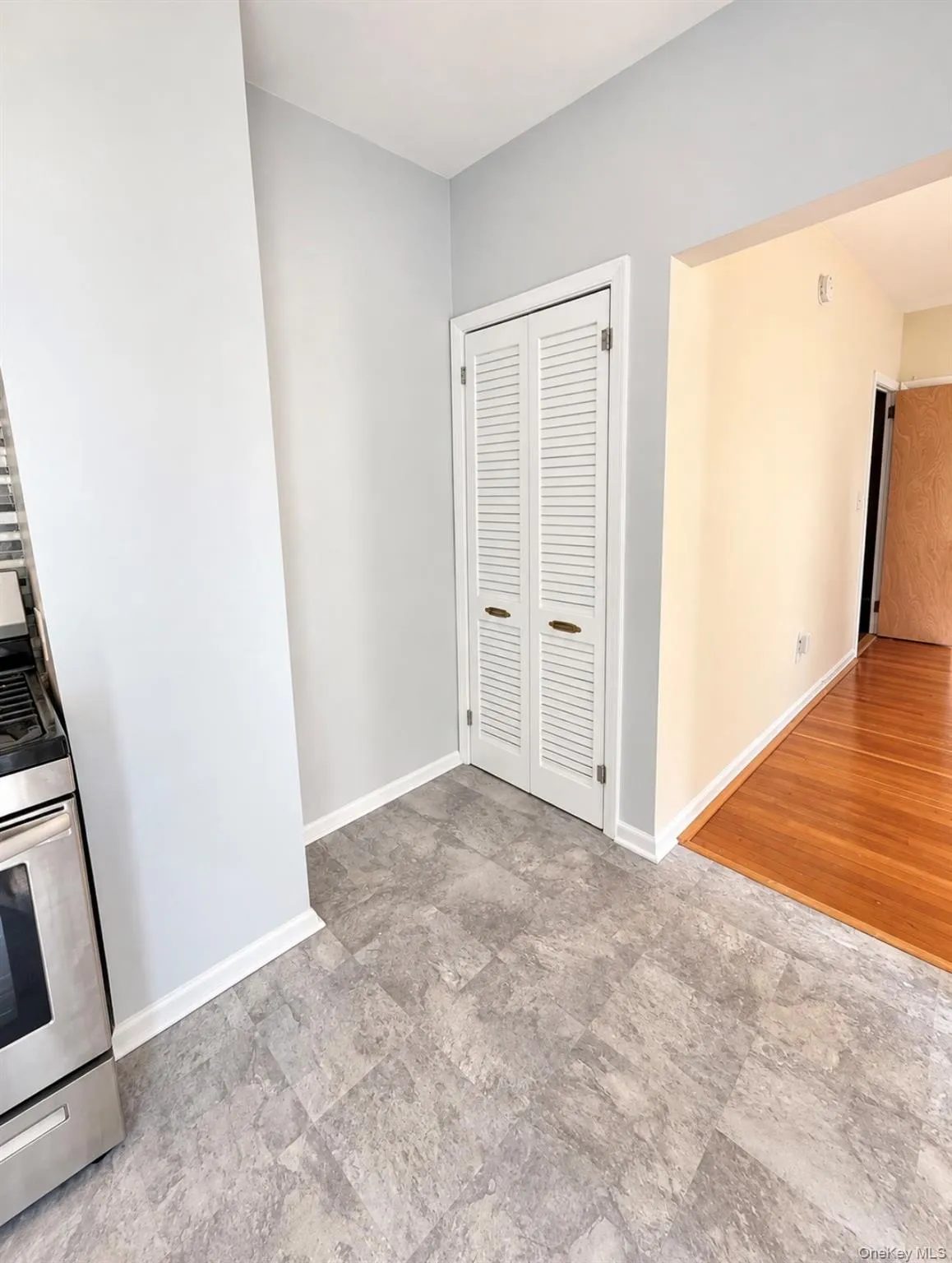 Stainless steel range, bi-fold louvered closet doors, stone-pattern vinyl flooring, and wood-finish flooring Stainless steel range, bi-fold louvered closet doors, stone-pattern vinyl flooring, and wood-finish flooring