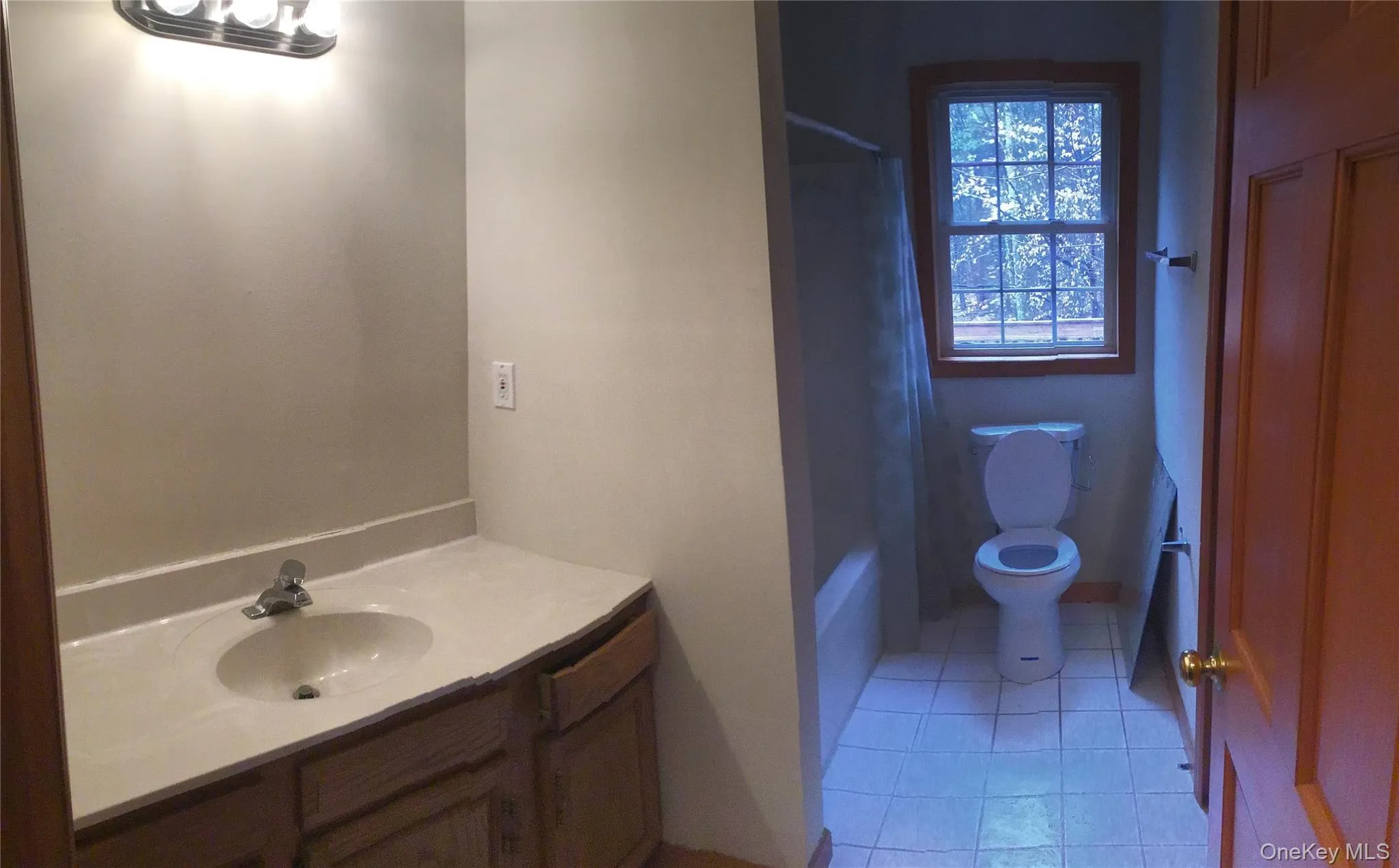 Bathroom with vanity, light tile patterned floors, and shower / washtub combination Bathroom with vanity, light tile patterned floors, and shower / washtub combination