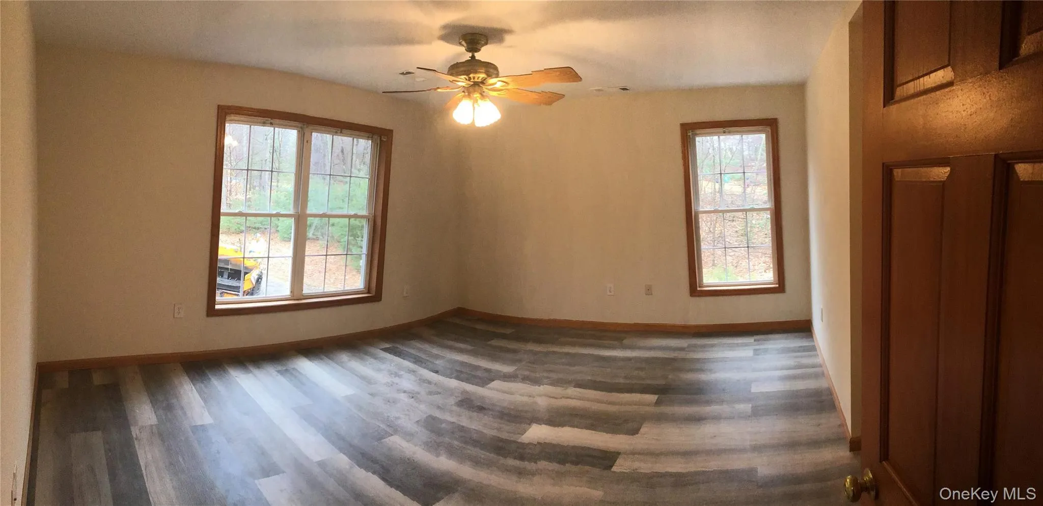 Spare room featuring dark wood-type flooring and ceiling fan Spare room featuring dark wood-type flooring and ceiling fan