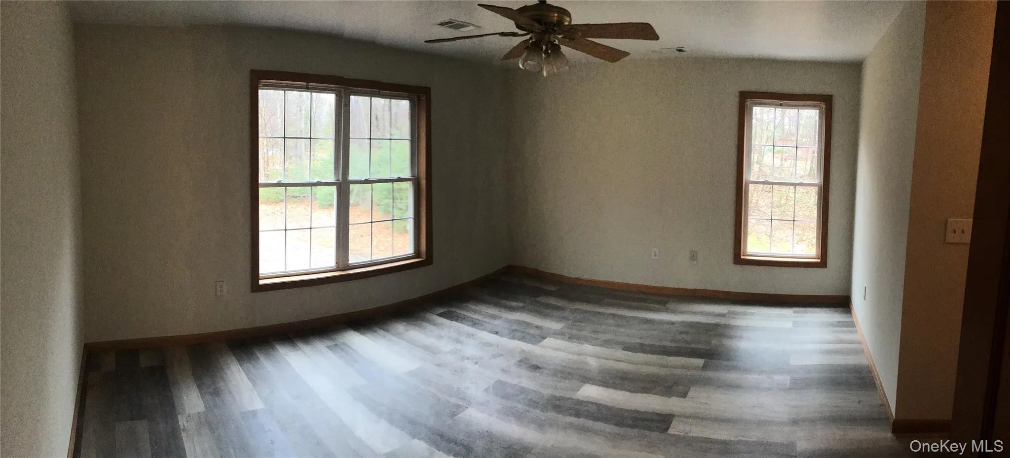 Spare room with dark wood-style flooring and ceiling fan Spare room with dark wood-style flooring and ceiling fan