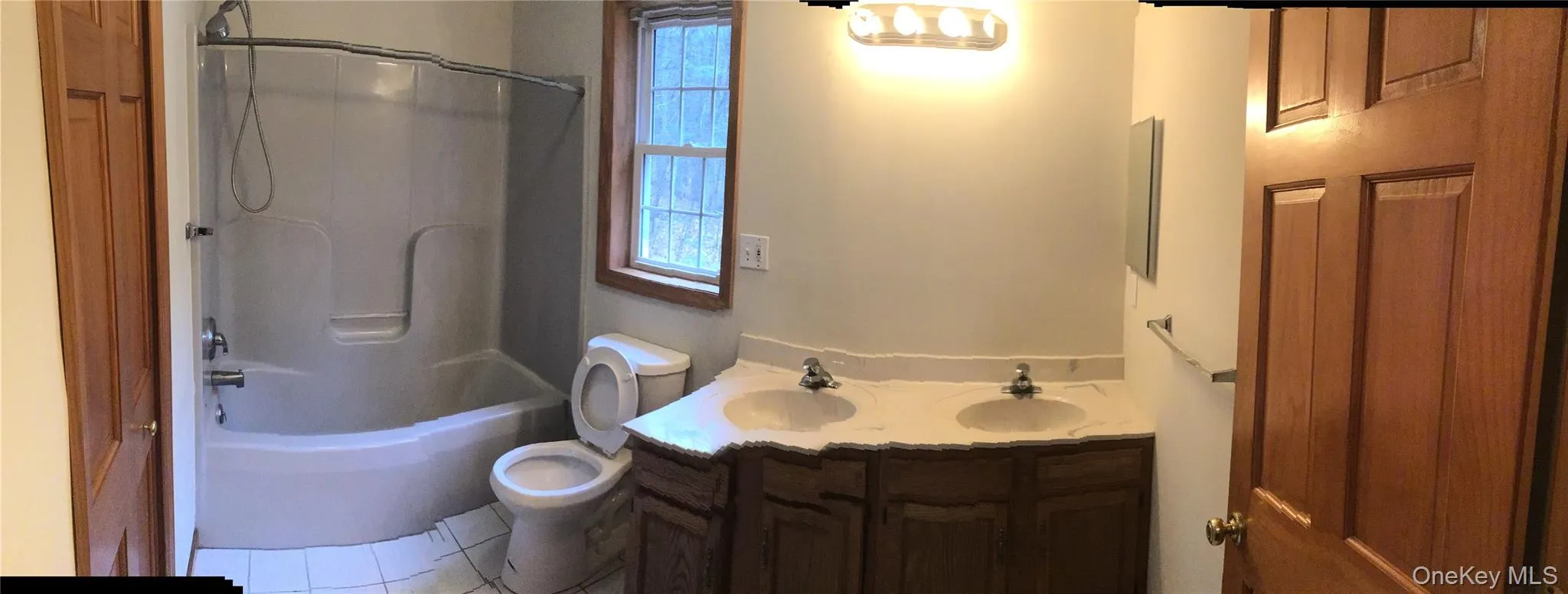 Full bathroom featuring washtub / shower combination and tile patterned flooring Full bathroom featuring washtub / shower combination and tile patterned flooring