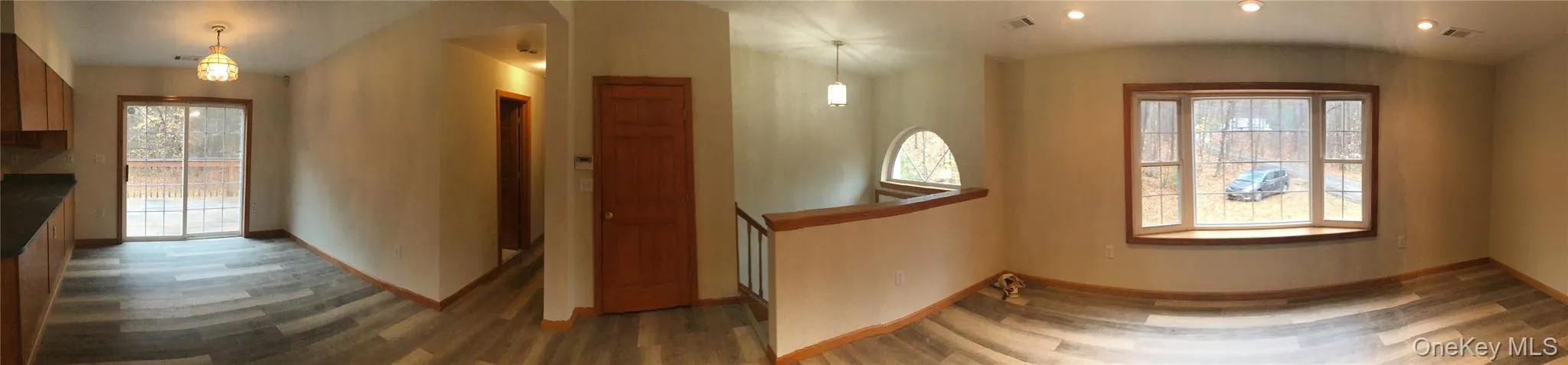 Hallway with vaulted ceiling, plenty of natural light, and dark wood-type flooring Hallway with vaulted ceiling, plenty of natural light, and dark wood-type flooring