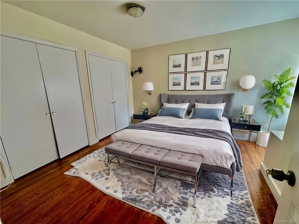 Virtually Staged - Upstairs Bedroom 1 with multiple closets and hardwood / wood-style floors Virtually Staged - Upstairs Bedroom 1 with multiple closets and hardwood / wood-style floors
