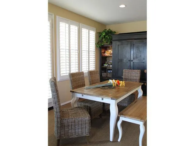Plantation shutters, high ceilings, and rich maple flooring lend a comfortable feeling to the dining area