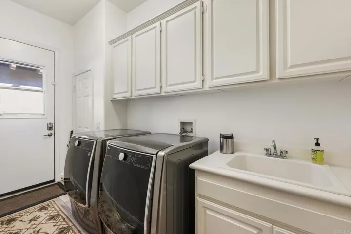 Large laundry room with sink and commercial grade washer and dryer