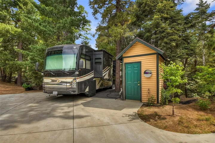RV Parking/Well House.
2 50 Amp Outlets, 1 30 amp outlet. Has Water, Electrical, and Sewer connection. 
Engineered Retaining Wall.