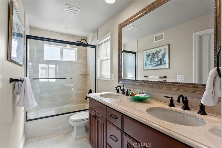 Sparkling Jack and Jill bath is perfect with double sink vanity and stone finishes.