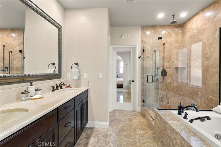 Lux master bath has jetted soaking tub, huge separate shower, dual sink vanity with storage, organized walk-in closet and is finished in gorgeous natural stone.  Five star accommodations here!
