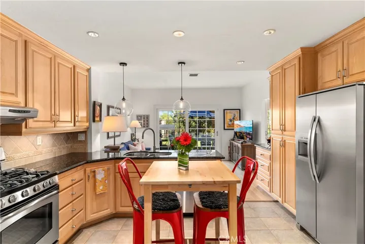 Remodeled kitchen with loads of cabinets and ample counter space. Touchless faucet, pendant lighting, open floor plan, pull out selves, stainless appliances including the double door refrigerator.