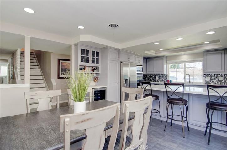 So many great details here...contemporary tile flooring, bar area with wine fridge and rack, solid tread stairway, recessed lighting and more!