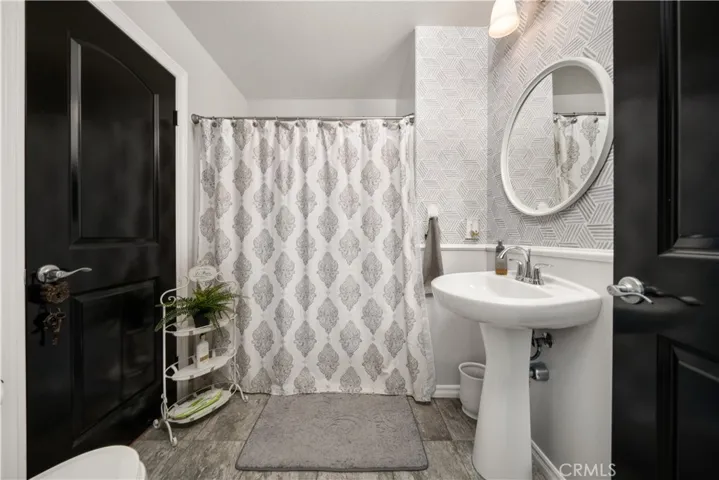 Front bathroom has a door to the hallway and a door to the downstairs bedroom. Full shower/tub, toilet and vanity sink.