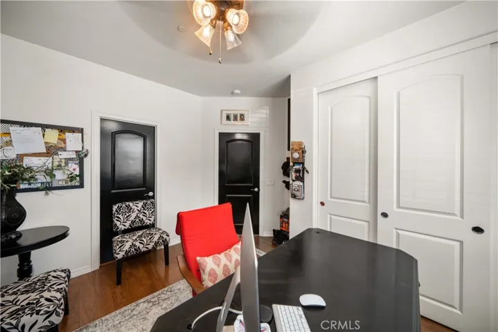 Another view of the front office/bedroom. Perfect for the overnight visitor, because it is seperated from the rest of the home! Dark wood door to the bathroom is behind the chair. Closet is in this photo. This is the only closet that is not a walk-in closet (like the rest of the home).