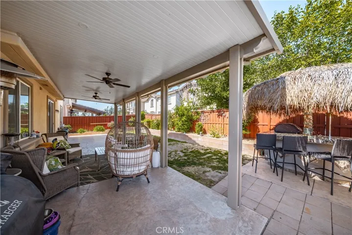 Another view of the massive patio with 2 ceiling fans and concrete underneath. BBQ Palapa with refrigerator is in the corner and really makes this a perfect spot to entertain, then take everyone accross the street to the park, swim or have a party under the Pavillion.