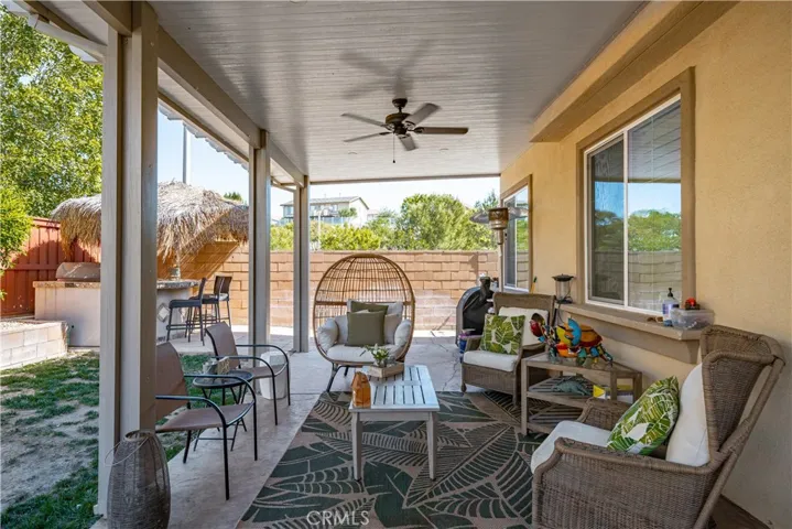 Backyard patio with 2 ceiling fans and recessed lighting  makes for great outdoor entertaining! Corner bar/bbq/refrigerator Palapa is granite trimmed and darling!