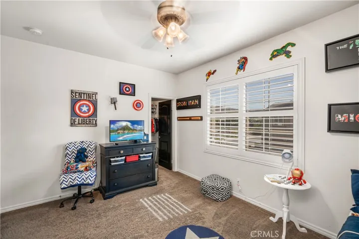 Another upstairs bedroom with walk-in closet! Dual paned plantation shutter windows. Beige carpet and custtom paint.