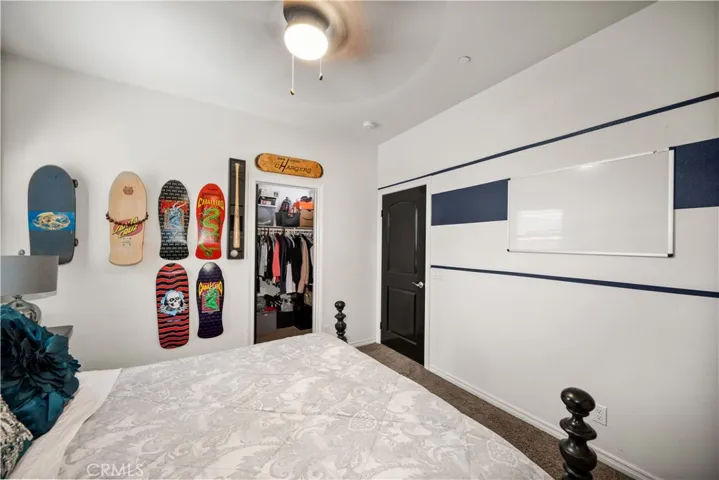 This photo allows you to see the walk-in closet, and dark wood door. Custom paint in this room as well.