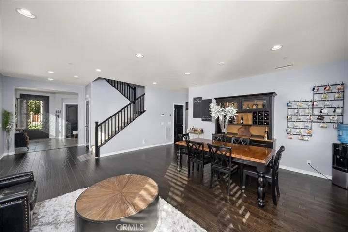 This view of the living room/dining room view twards the front door allows you to see how enormous the room is. Real wood flooring, with dark wood trimmed staircase and doors allow you to see the carefully well thought out floorplan that is oppulant!