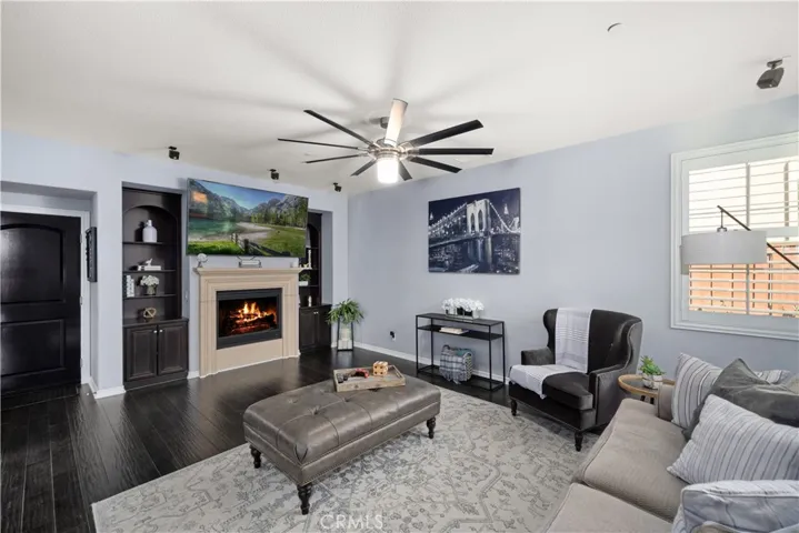 The dark cupboards around the fireplace were cleverly designed for even more storage. Door next to the entertainment center leads to your epoxy poured  3 car garage with storage shelves (staying)! This family room opens to the kitchen and blends seamlessly. Tons of plantation shutter dual paned windows makes the space naturally light and bright.