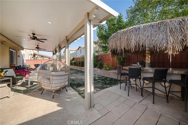 Back yard patio boasts recessed lighting and ceiling fans. Grass area is before your retaining wall with lime fruit tree and greenery. BBQ Palapa island makes for a fun place to gather, and enjoy getting a refreshing beverage out of the refrigerator underneath. Island is trimmed nicely with granite. There is also a shed and dog run behind the cameraman! This house has it ALL!! It is the entertainers home! After your house gathering, you can walk accross the street to the Pool, Pavillion and park!!