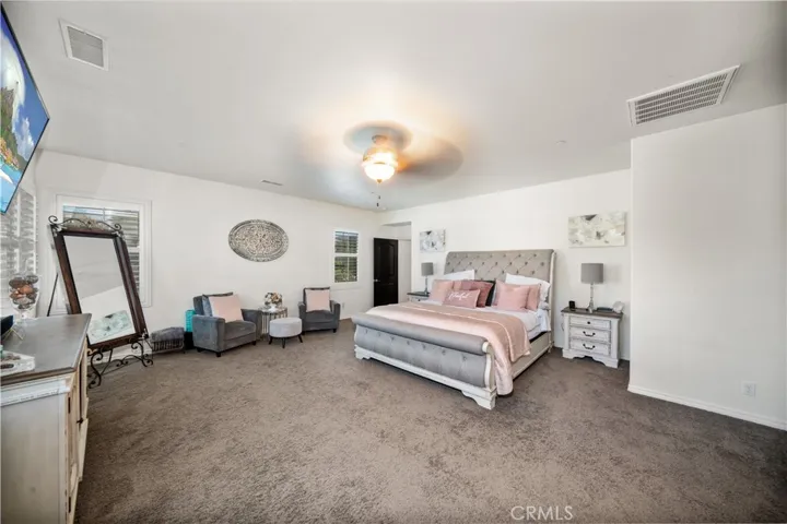 Primary suite is massive and stunning! Bed, sitting area and room for more furniture! Ceiling fan above. Tons of dual paned windows surround the room with plantation wood shutter coverings! The floor plan is amazing, as this primary is totally seperated from the other 3 upstairs bedrooms!