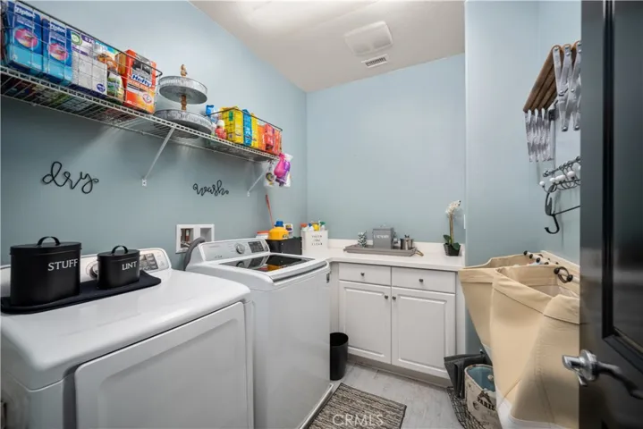 Upstairs laundry room is spacious and convienent! Oversized white cupboard with countertop allows for a great place to fold cloths and store things. Shelf above the washer/dryer holds the detergent things. Tiled flooring means it is easy to clean.