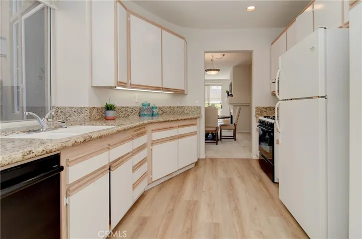 Efficient kitchen has plenty of prep and cabinet space...natural stone counters and new EZ care vinyl plank flooring too.
